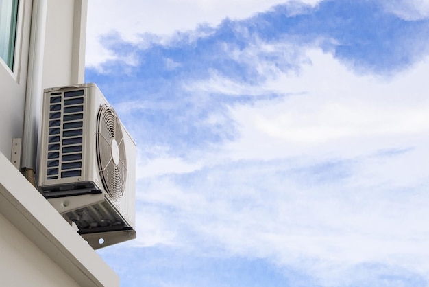 Compressor da unidade externa de ar condicionado instalado fora da casa com céu azul