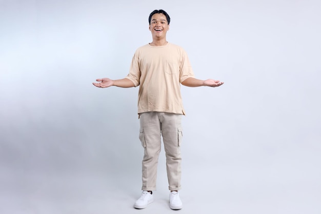 Comprimento completo de jovem asiático mostrando ambas as mãos abertas palmas apresentando produtos de comparação