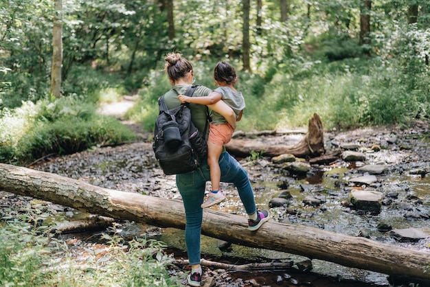 Comprimento completo de mãe e filha a caminhar na floresta