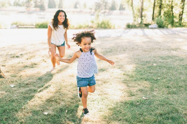 Comprimento completo de mãe e filha a caminhar no campo