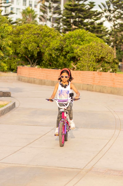 Comprimento completo de menina andando de bicicleta na calçada