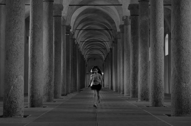 Foto comprimento completo de menina correndo em edifício histórico