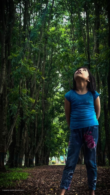 Foto comprimento completo de menina de pé na floresta