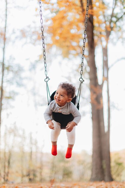 Foto comprimento completo de menino em balanço no playground