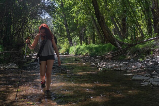 Foto comprimento completo de mulher a caminhar na floresta