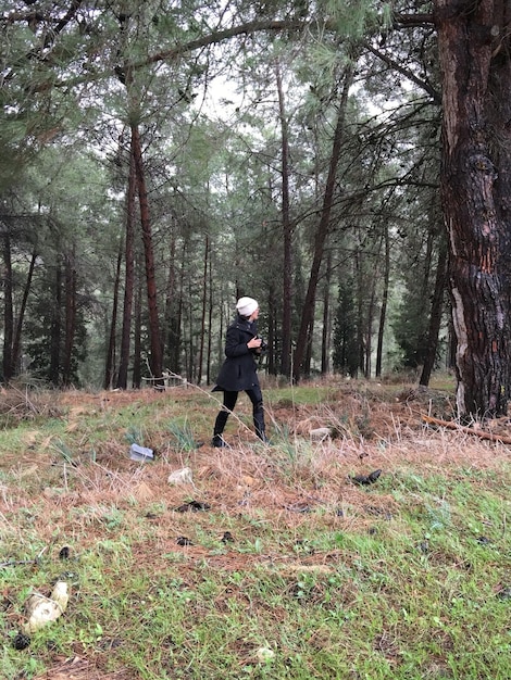 Comprimento completo de mulher caminhando na floresta