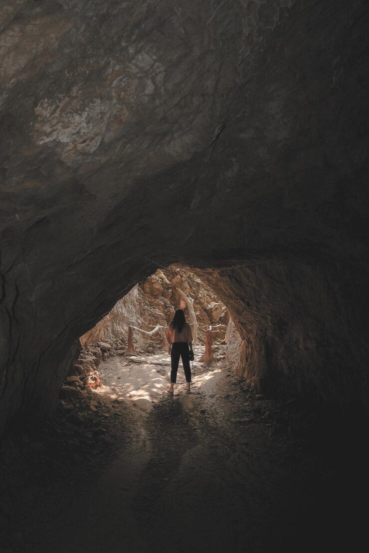 Foto comprimento completo de mulher de pé na caverna