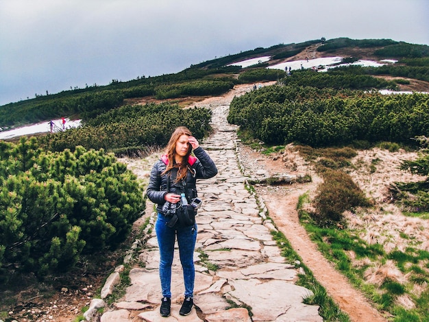 Foto comprimento completo de mulher de pé na montanha