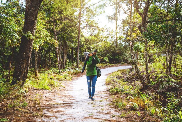 Foto comprimento completo de mulher jovem fotografando com câmera na floresta