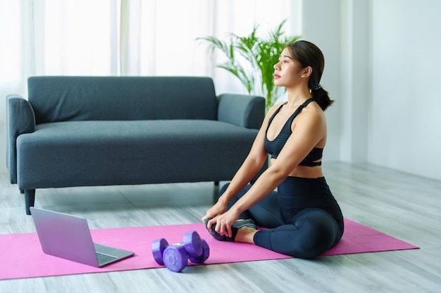 Comprimento completo de mulher jovem se exercitando em casa