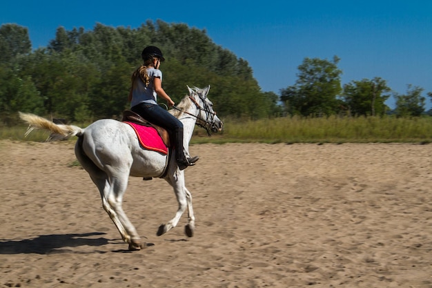 Comprimento completo de mulher montando cavalo no campo