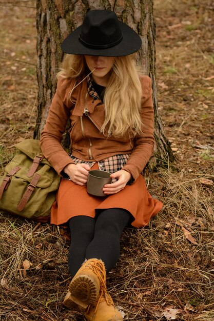 Foto comprimento completo de mulher usando telefone móvel no campo