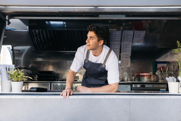 Comprimento completo de um jovem de pé na cozinha