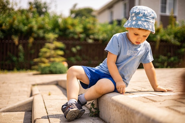 Foto comprimento completo de um menino sentado em madeira