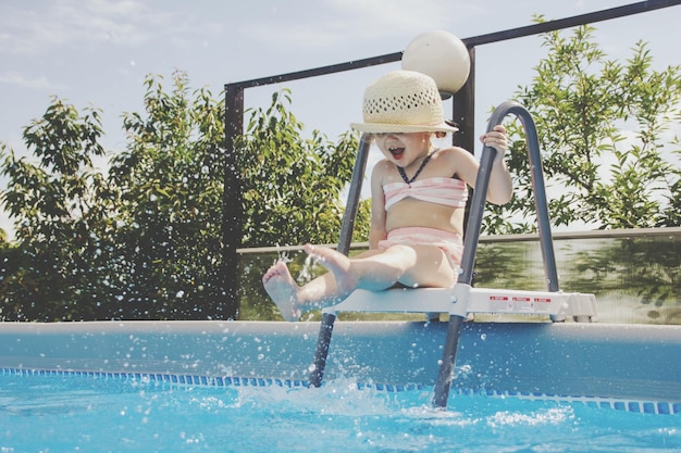 Comprimento total da mulher a saltar na piscina contra o céu