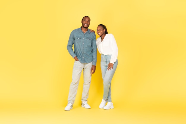 Comprimento total de casal afro-americano posando sobre fundo amarelo