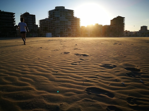 Foto comprimento total de homem a caminhar na praia