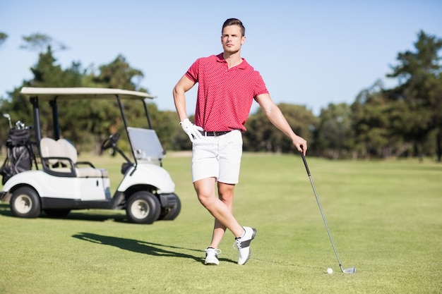 Comprimento total de jovem golfista com mão no quadril