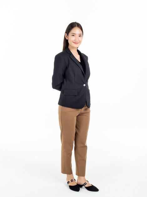 Comprimento total de uma jovem e bonita mulher de negócios asiática de terno preto e calça marrom em pé