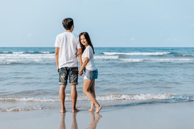 Comprimento total do casal na praia contra o céu