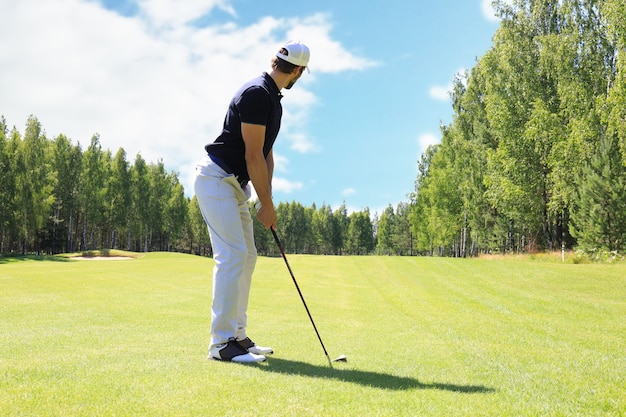 Comprimento total do jogador de golfe jogando golfe em um dia ensolarado. jogador de golfe profissional, levando tiro no campo de golfe.