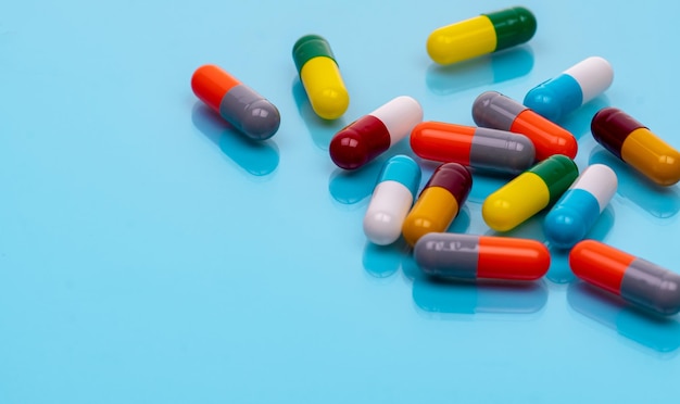 Comprimidos cápsula antibiótica em fundo azul Medicamentos prescritos Comprimido cápsula colorida Medicamento antibiótico
