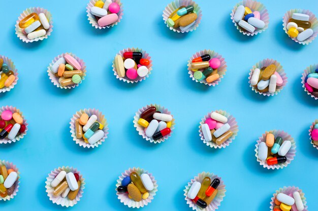 Comprimidos coloridos com cápsulas e comprimidos em embalagens de cupcake