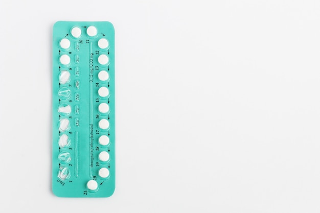 Comprimidos contraceptivos em fundo branco