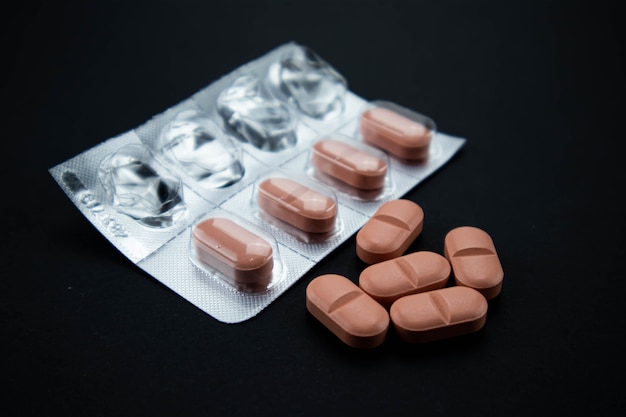 Foto comprimidos cor de rosa de medicamento farmacêutico com espaço de cópia