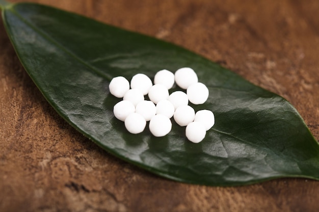 Comprimidos de homeopatia na folha verde closeup