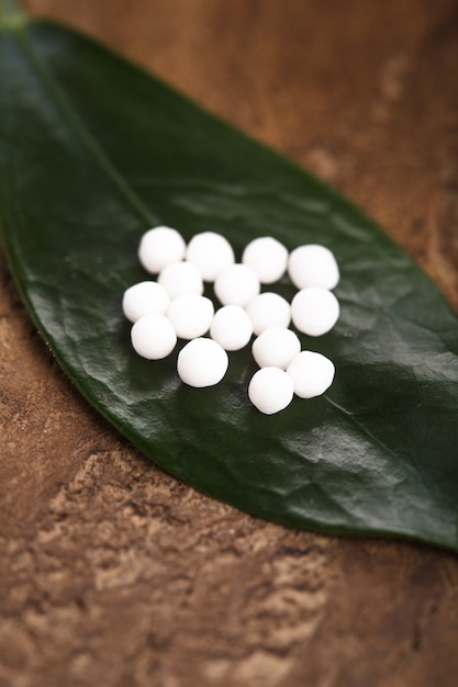 Comprimidos de homeopatia na folha verde closeup