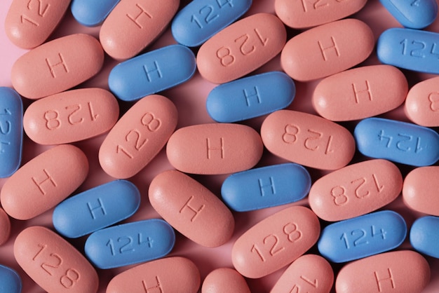 Comprimidos de terapia de HIV/AIDS em fundo rosa