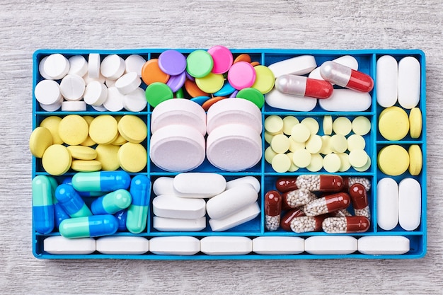 Comprimidos e cápsulas em recipiente. Remédios médicos para pacientes.