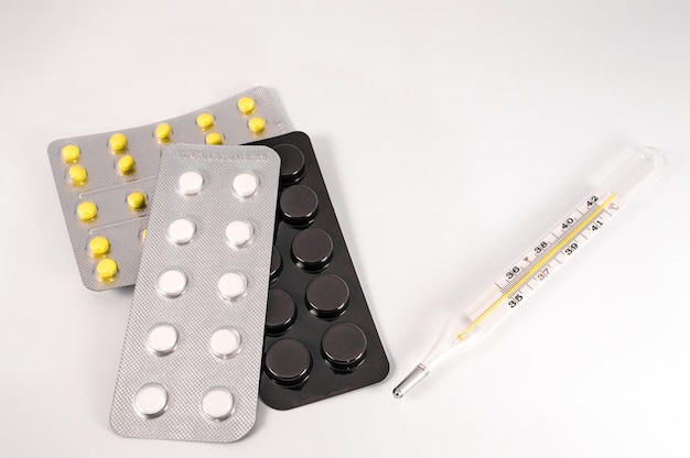 Comprimidos e comprimidos médicos brancos sobre fundo branco foto aproximada de preparações médicas com espaço de cópia