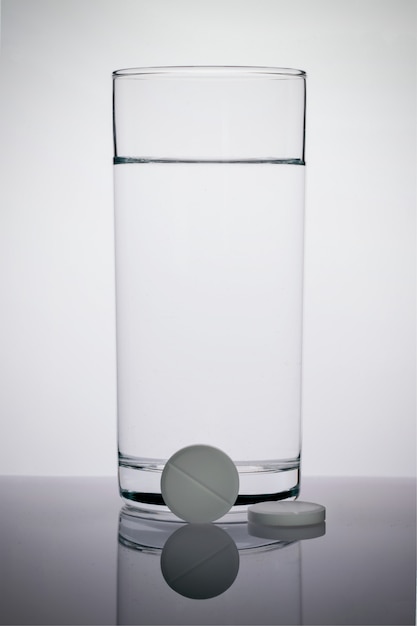 Foto comprimidos efervescentes e um copo de água