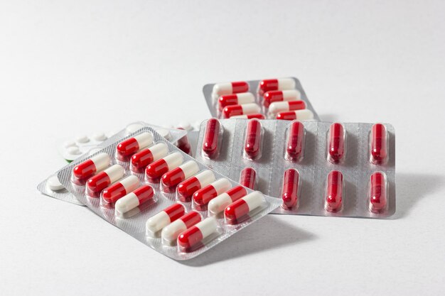 Comprimidos medicinais vermelhos e brancos em fundo branco