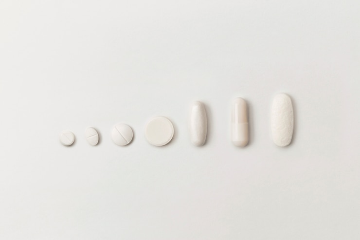 Foto comprimidos médicos de várias formas em um fundo branco