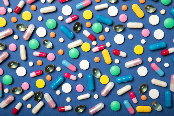 Foto comprimidos multicoloridos sobre uma superfície azul. medicina e saúde.