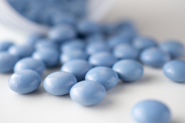 Comprimidos remédios azuis com frasco em fundo branco