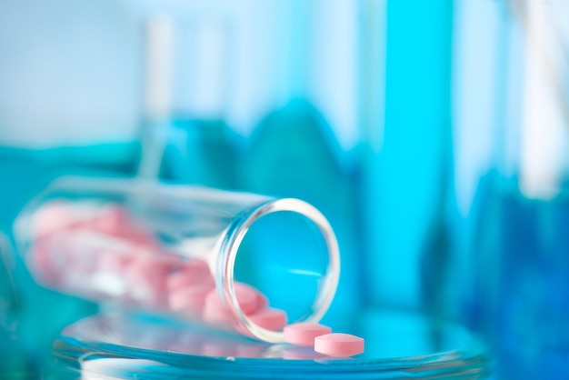 Comprimidos rosados en un tubo de ensayo químico Producción de medicamentos Medicina productos farmacéuticos química