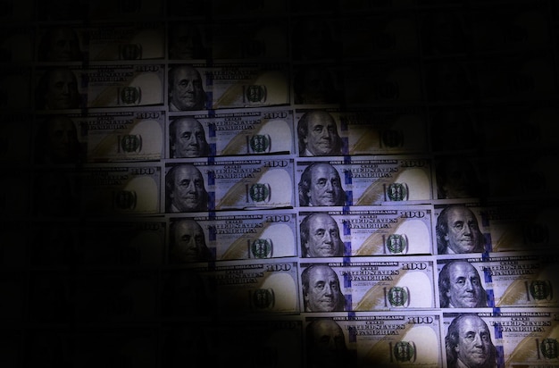 Foto comprobación de dinero falsificado con lámpara ultravioleta delito de fraude crisis financiera y económica billetes en dólares tasa de inflación concepto de robo