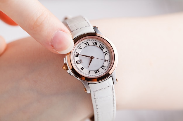 Comprobación del tiempo, reloj de pulsera femenino en mano