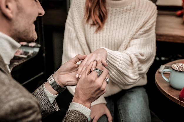 El compromiso. Hombre poniendo un anillo en el dedo de su socio