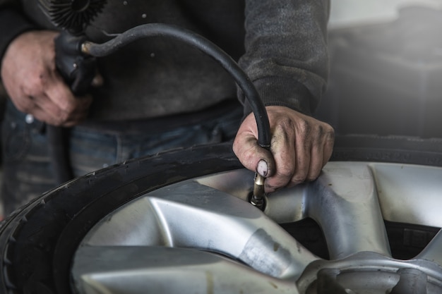 Comprueba la presión de los neumáticos mientras trabaja en un taller de reparación