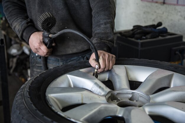 Comprueba la presión de los neumáticos mientras trabaja en un taller de reparación