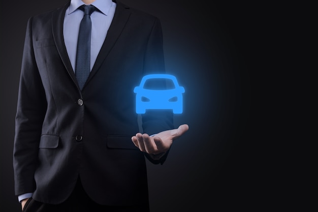 Foto compuesto digital de hombre sujetando el icono de coche. seguro de automóvil y servicios de automóvil.