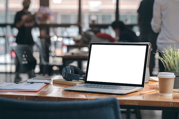 Computador laptop com tela em branco de maquete com suprimentos na mesa de madeira