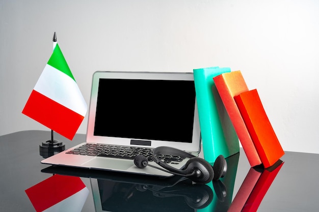 Computador portátil com bandeira italiana na mesa de trabalho conceito educacional