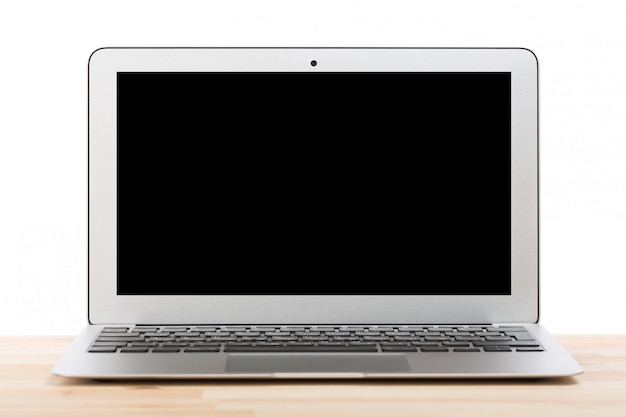 Computador portátil com tela preta em branco na mesa de madeira clara. Isolado.
