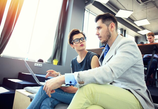 Foto computador portátil conceito diversidade equipa de negócios start up finanças analisar pessoas relatório reunião trabalho de equipa trabalhar processogrupo jovens hipsters discutir escritório